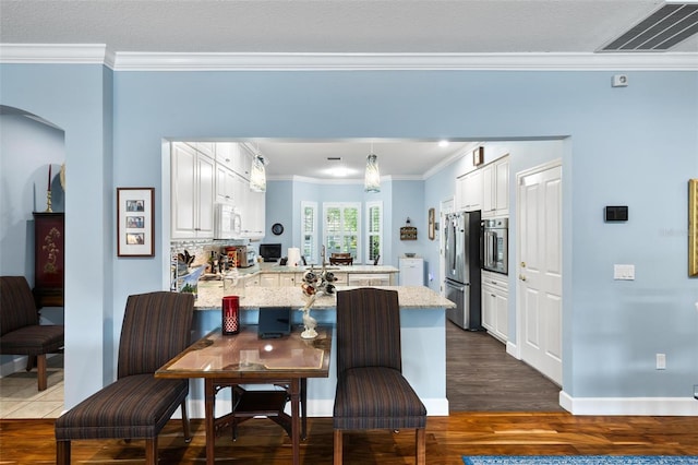 dining space with ornamental molding and wood-type flooring