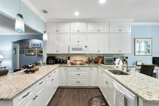 kitchen featuring backsplash, sink, kitchen peninsula, dishwashing machine, and decorative light fixtures