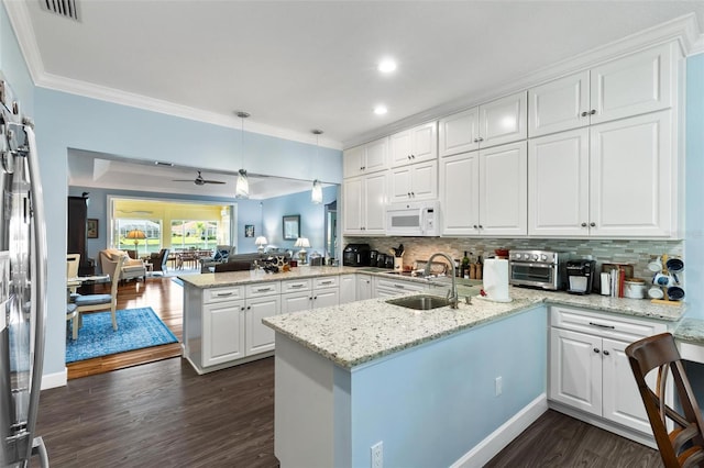 kitchen featuring dark hardwood / wood-style floors, white cabinetry, sink, decorative backsplash, and kitchen peninsula