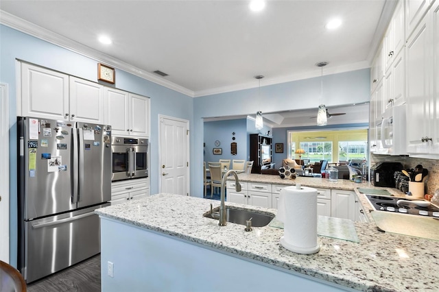 kitchen with white cabinets, stainless steel appliances, sink, and kitchen peninsula