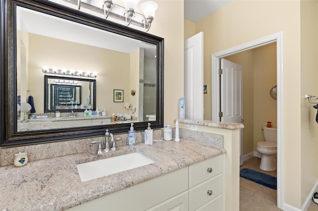 bathroom featuring toilet, vanity, and tile patterned flooring