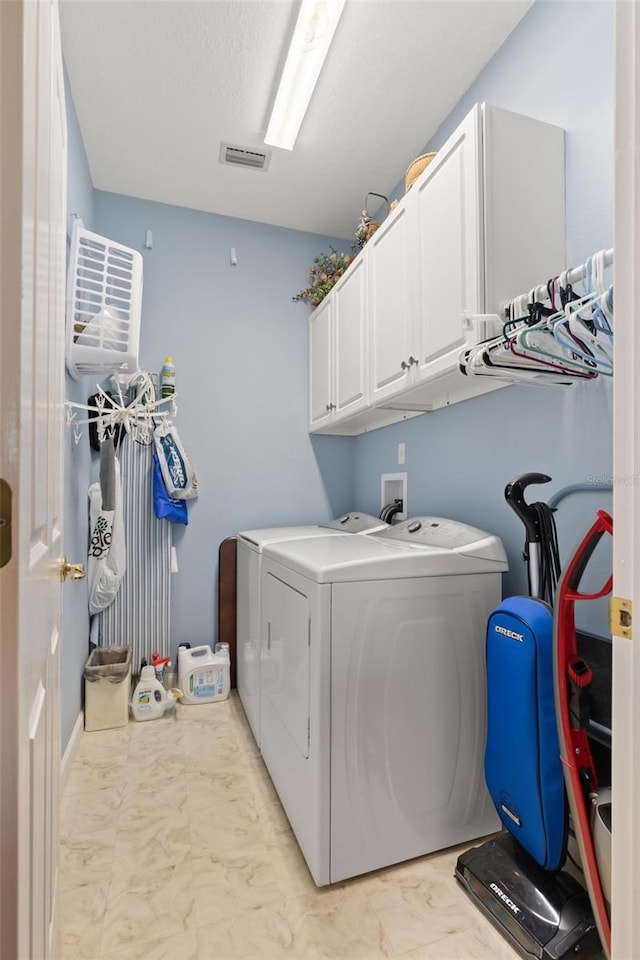 laundry room featuring washing machine and dryer and cabinets