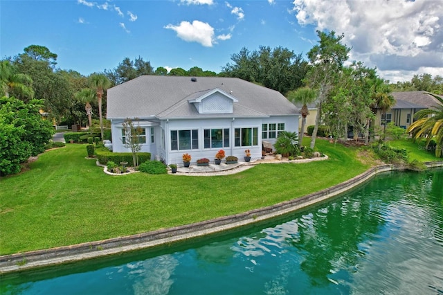 rear view of property featuring a lawn