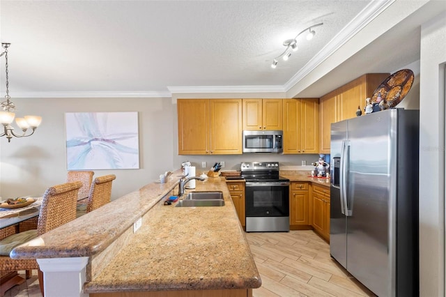 kitchen with sink, appliances with stainless steel finishes, track lighting, a textured ceiling, and kitchen peninsula