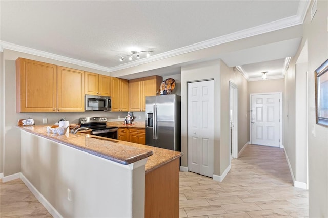 kitchen with stainless steel appliances, baseboards, a peninsula, and ornamental molding