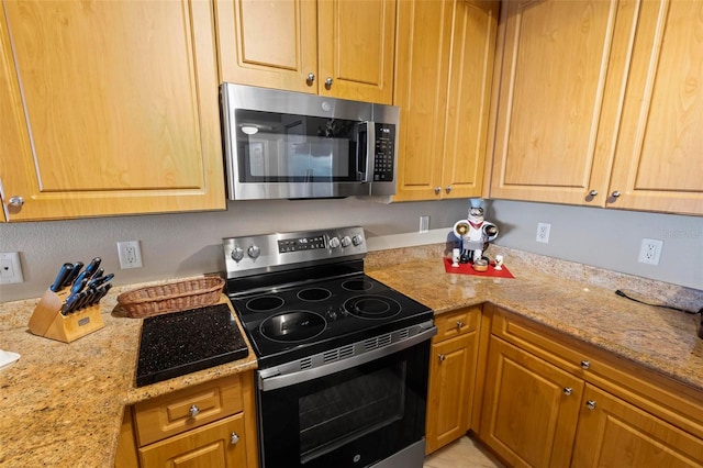 kitchen featuring stainless steel appliances and light stone counters