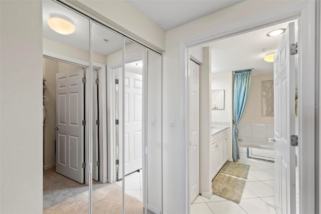 hallway with light tile patterned floors and light carpet