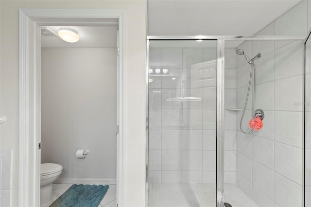 bathroom with tile patterned floors, a shower with door, and toilet