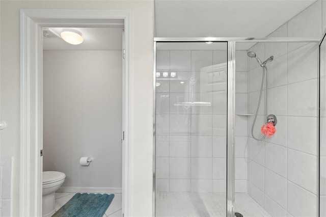 bathroom featuring tile patterned flooring, a shower stall, toilet, and baseboards