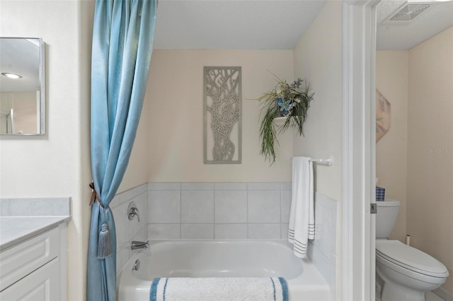 bathroom with toilet, a tub to relax in, and vanity