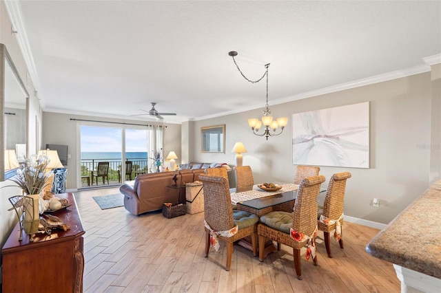 dining room featuring light hardwood / wood-style floors, ceiling fan with notable chandelier, ornamental molding, and a water view