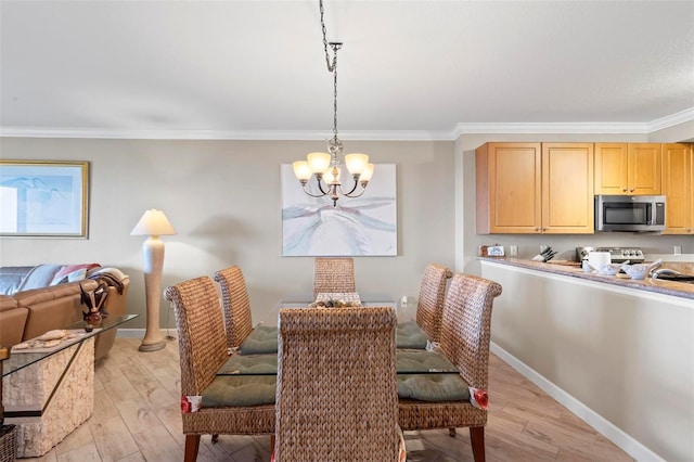 dining space featuring light hardwood / wood-style floors, ornamental molding, and an inviting chandelier