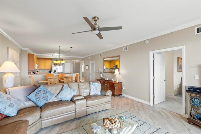 living room featuring light carpet, ceiling fan with notable chandelier, and ornamental molding