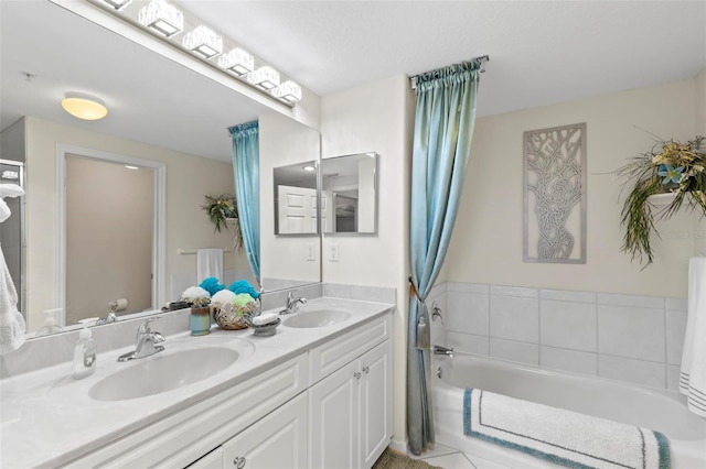 bathroom with double sink vanity, tile patterned floors, and a tub