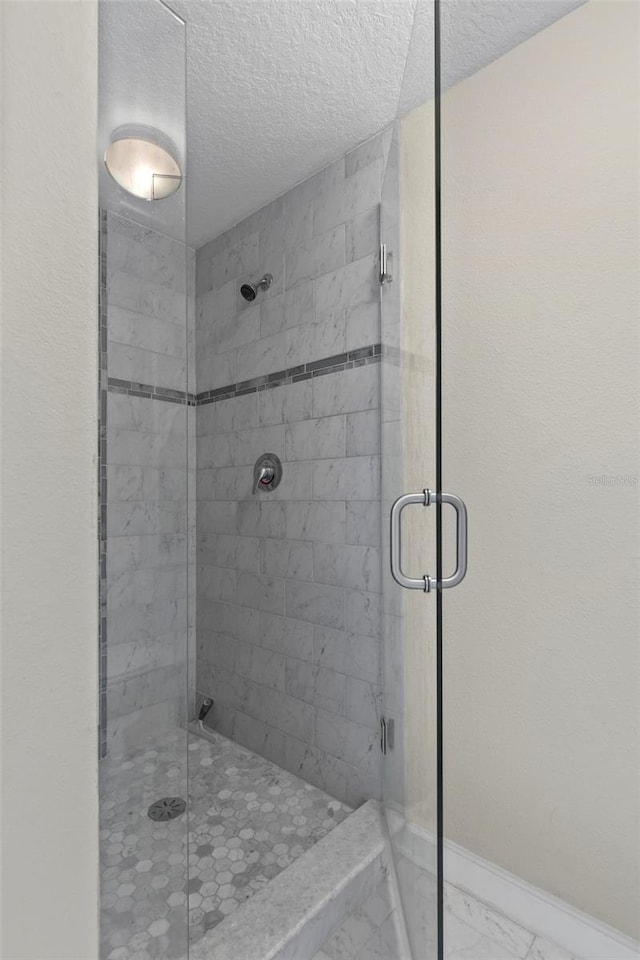 bathroom featuring a textured ceiling and walk in shower