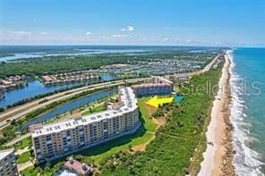 drone / aerial view featuring a beach view and a water view