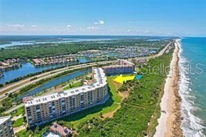 aerial view with a water view and a view of the beach