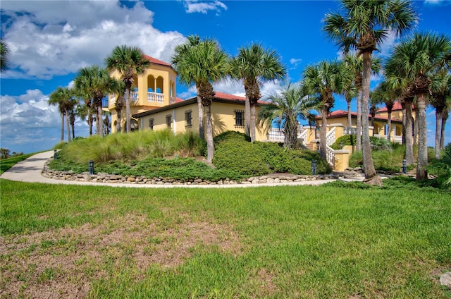 exterior space with stucco siding, a lawn, and a tile roof