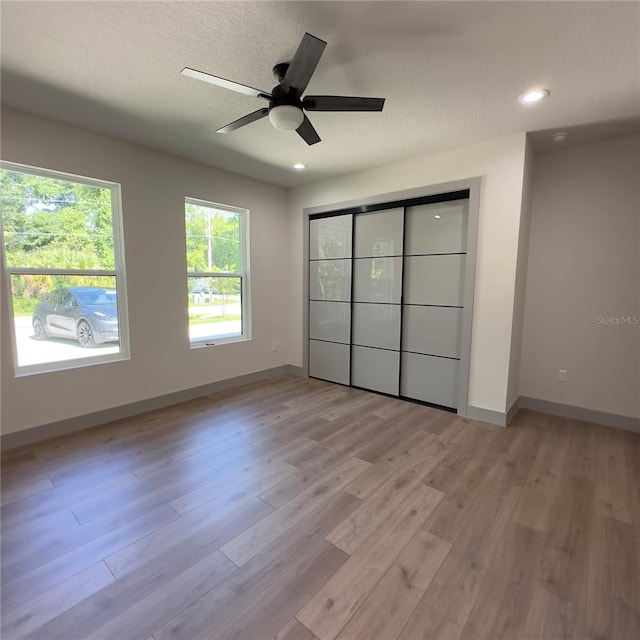 unfurnished bedroom with light hardwood / wood-style flooring and ceiling fan