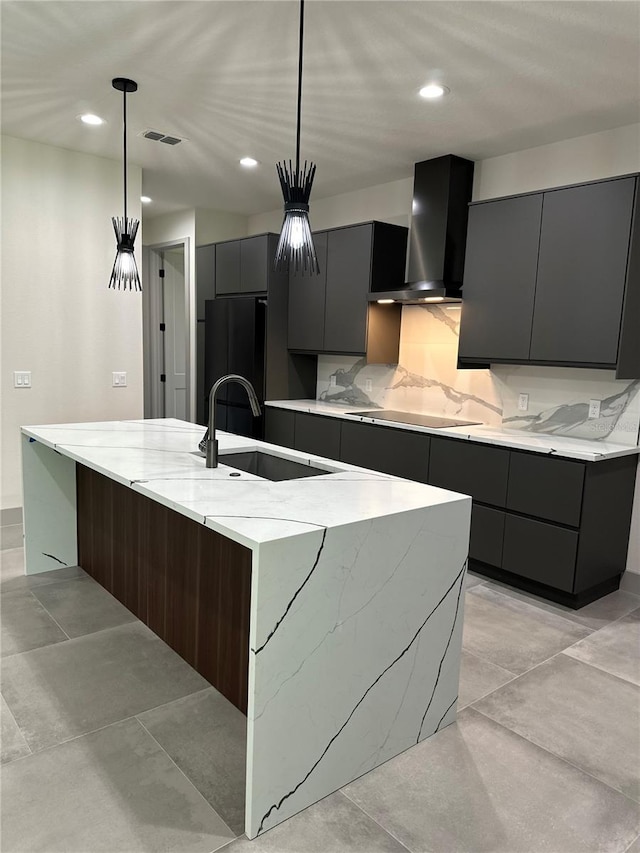 kitchen featuring sink, decorative light fixtures, wall chimney exhaust hood, a large island, and black appliances