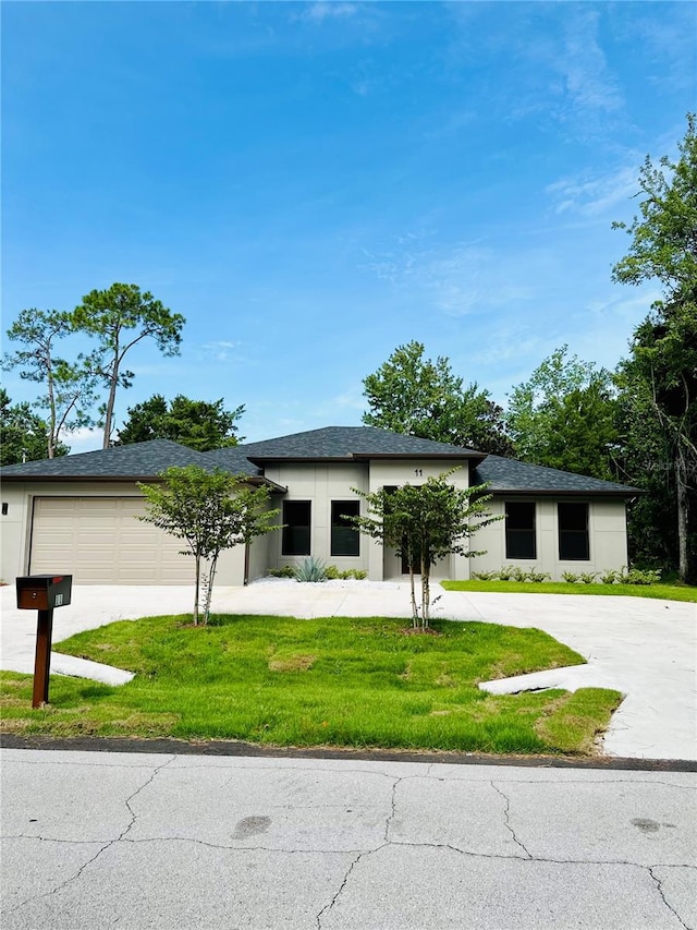 view of front of property featuring a garage and a front lawn