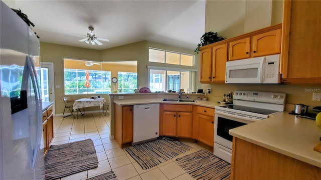 kitchen with sink, lofted ceiling, white appliances, ceiling fan, and light tile patterned flooring