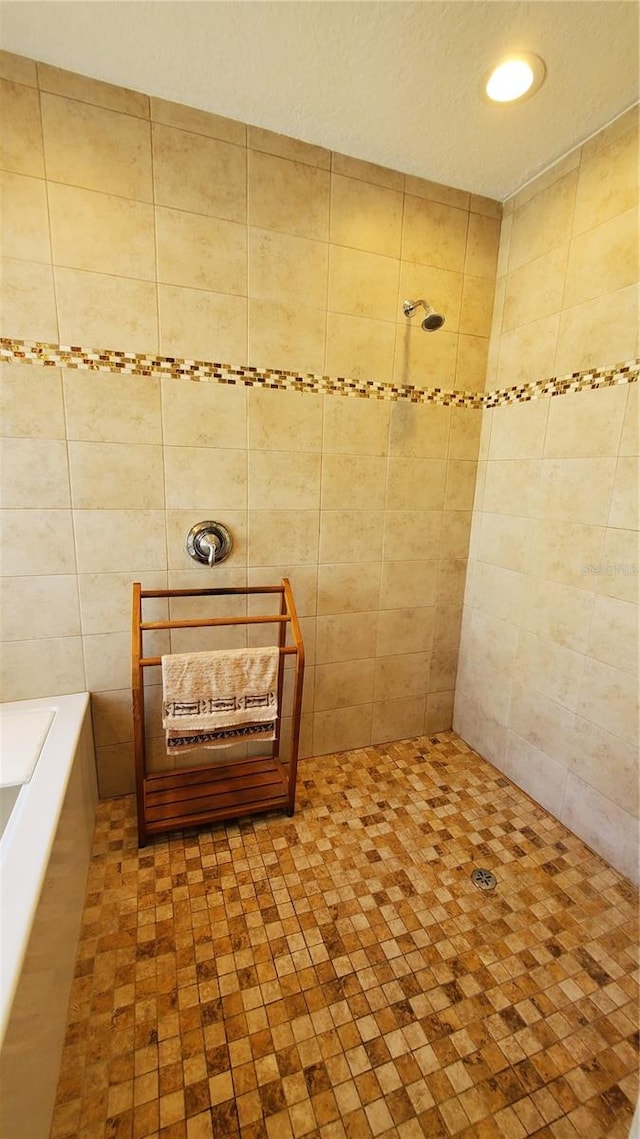 bathroom featuring tile walls and separate shower and tub