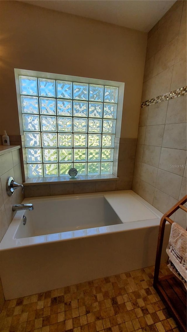 bathroom with a bath and tile patterned floors