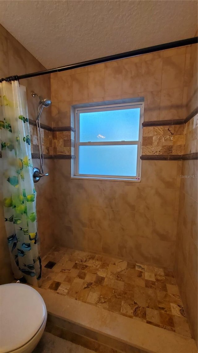 bathroom with toilet, plenty of natural light, and walk in shower