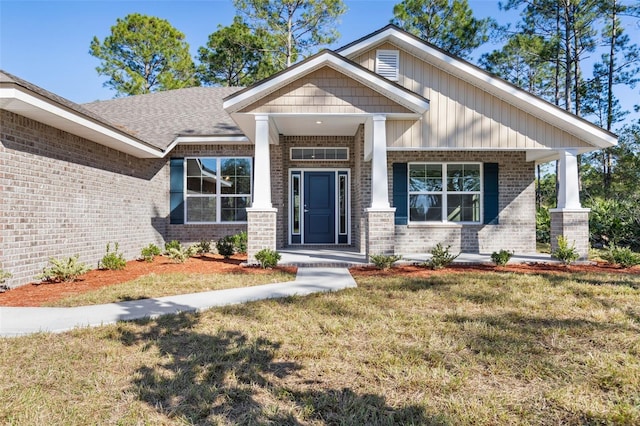 craftsman inspired home featuring a front lawn and covered porch