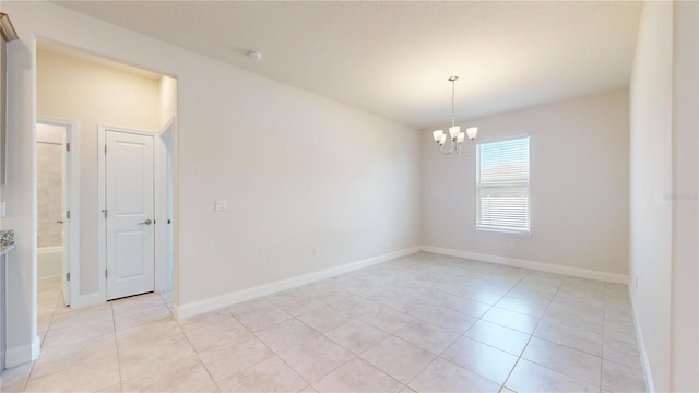 empty room with an inviting chandelier and light tile patterned floors