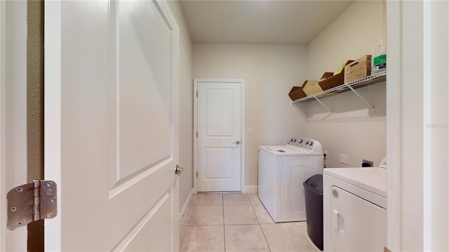 laundry room featuring washing machine and dryer and light tile patterned floors