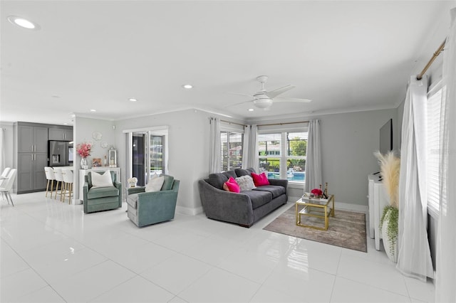 living room with light tile patterned floors, ornamental molding, and ceiling fan