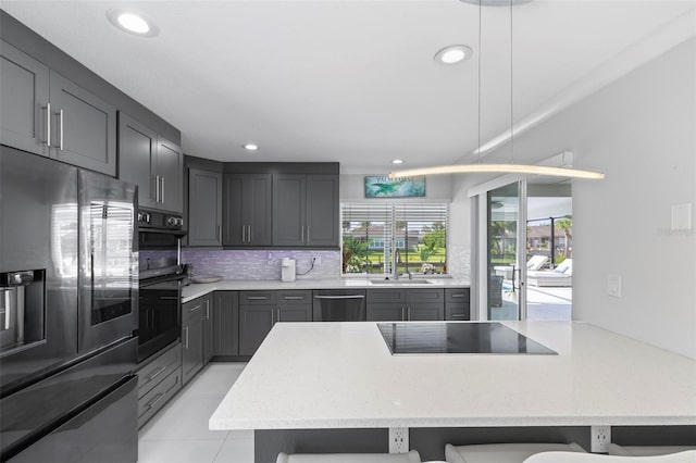 kitchen featuring stainless steel appliances, a breakfast bar, a peninsula, a sink, and backsplash