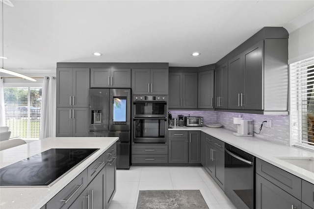kitchen featuring light tile patterned floors, recessed lighting, gray cabinetry, decorative backsplash, and black appliances