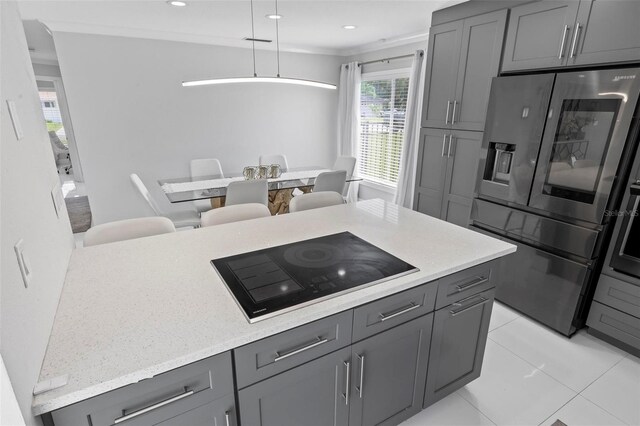 kitchen with black electric stovetop, stainless steel refrigerator with ice dispenser, gray cabinetry, light tile patterned floors, and decorative light fixtures