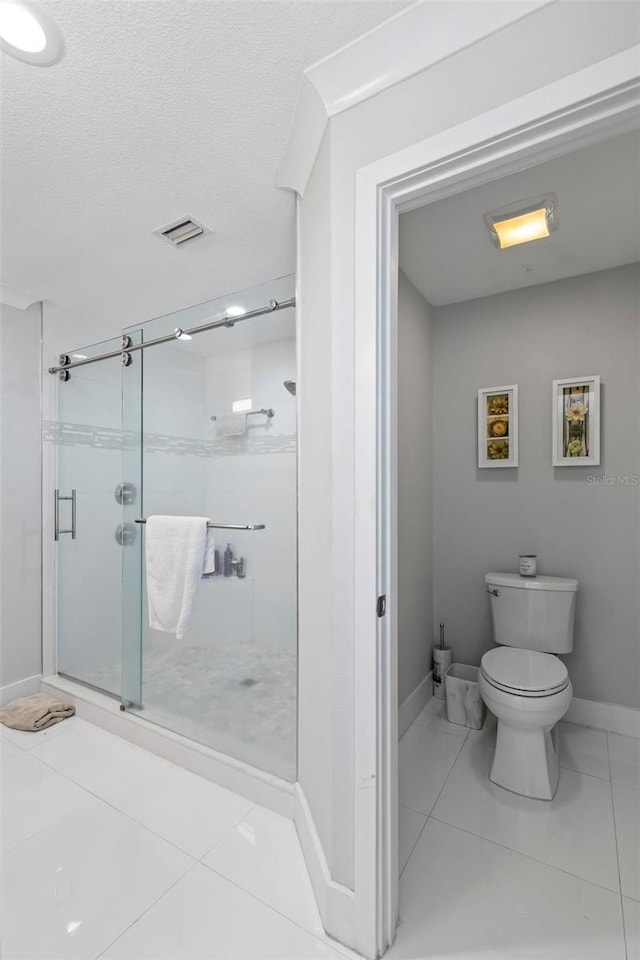 full bathroom with a textured ceiling, toilet, visible vents, baseboards, and a stall shower