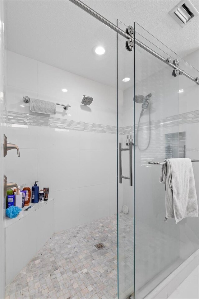 bathroom featuring walk in shower, tile patterned floors, and a textured ceiling