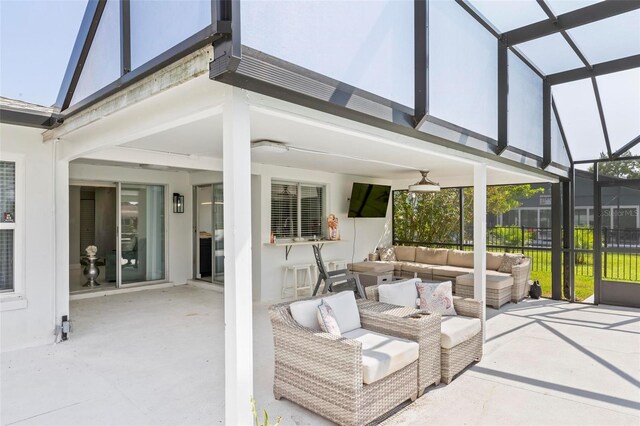 view of patio / terrace featuring ceiling fan, an outdoor living space, and glass enclosure