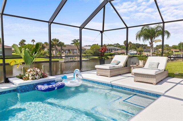 view of swimming pool with glass enclosure, a patio, and a water view