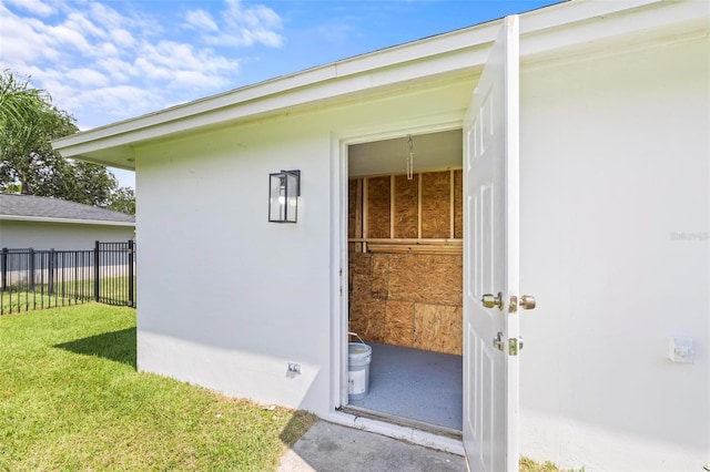 view of exterior entry with a lawn