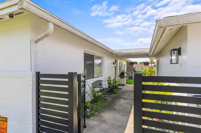 view of side of property with fence and stucco siding