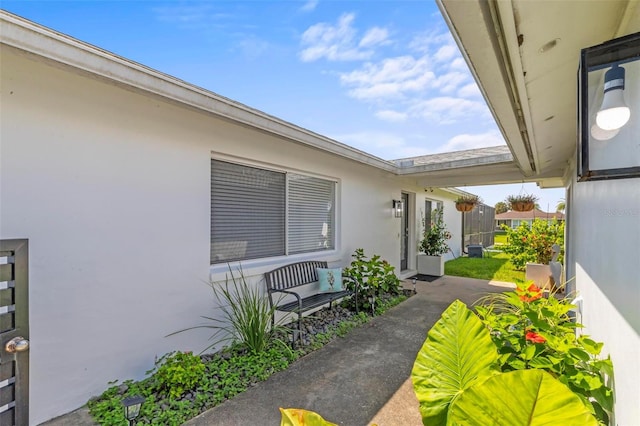 exterior space featuring a patio area, fence, and stucco siding