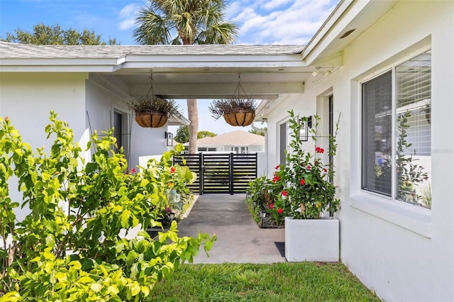exterior space featuring a patio area, a shingled roof, fence, and stucco siding