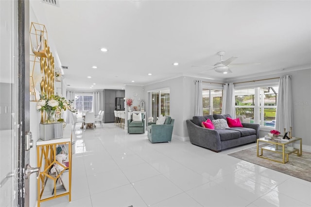 tiled living room with ceiling fan and crown molding