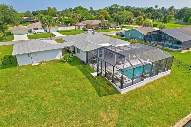 view of swimming pool featuring a lawn and a lanai