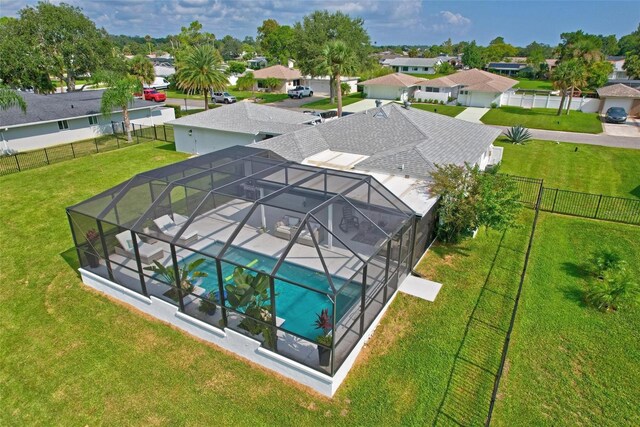 view of pool featuring a lawn and a lanai