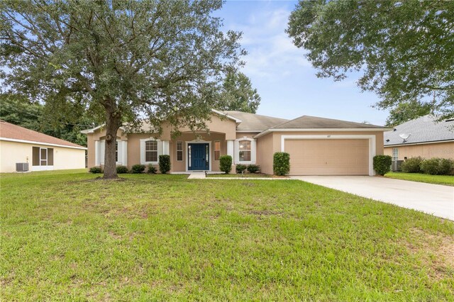 ranch-style home featuring a garage, central AC, and a front yard