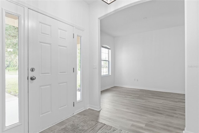 foyer entrance with wood finished floors and baseboards