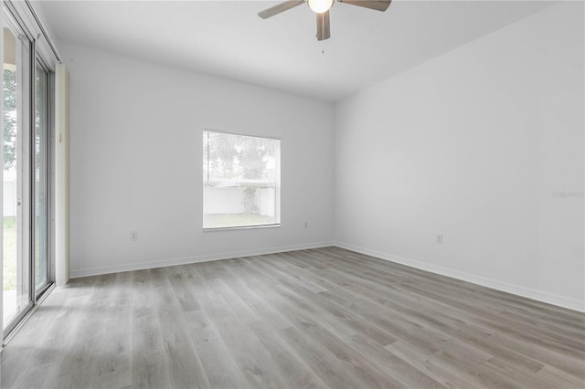 spare room with plenty of natural light, baseboards, and wood finished floors